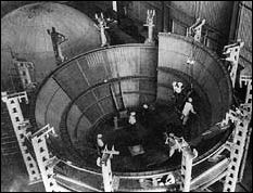 the final segment of an S-ll stage thrust structure is lowered into place