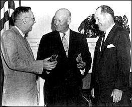 President Dwight D. Eisenhower presents commissions as the first Administrator and Deputy Administrator of the new National Aeronautics and Space Administration to Dr. T. Keith Glennan (right) and Dr. Hugh Dryden.