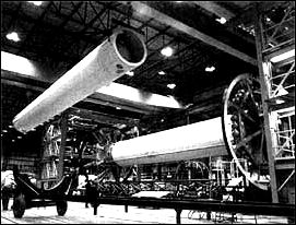 Below, in MSFC's Fabrication and Engineering Laboratory an S-l is being assembled. The two end spider beams are connected to the central 267-centimeter diameter liquid-oxygen tank; the first of the eight 178-meter outer tanks, used alternately for liquid oxygen and kerosene, is being lifted into position