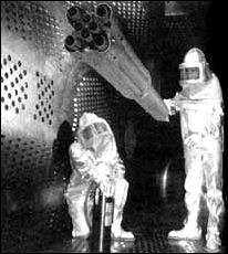 engineers in a Lewis Research Center wind tunnel are aligning a model of the Saturn IB prior to firing tests to determine the amount and distribution of base heating from the blast of the eight engines
