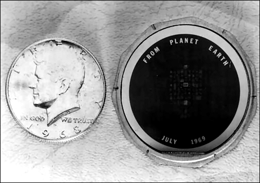 Closeup showing the goodwill message disc (right) compared in size to that of a Kennedy half dollar. 