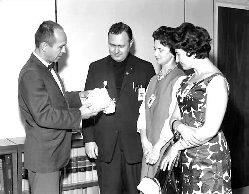 Maxime A. Faget, assistant director for engineering and development, Manned Spacecraft Center, explains the function of the lunar excursion module to Father Patrick J. O'Brien, Mrs. Faget, and Mrs. Donald J. O'Brien, sister-in-law to Father O'Brien. This photo was taken on September 15, 1965.