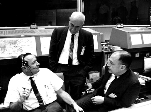 Discussing the scrub of the Gemini VI space flight are (from left), Christopher C. Kraft Jr., Red Team flight director; Dr. Robert R. Gilruth, center director; and George M. Low, deputy director.